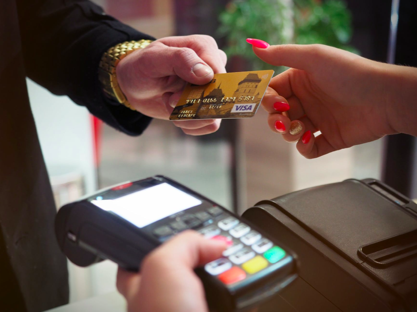 photo-of-person-handing-dutch-bank-credit-card-to-person-holding-payment-terminal