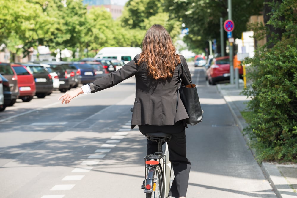 Young-woman-signaling-before-turning-while-cycling-in-the-Netherlands