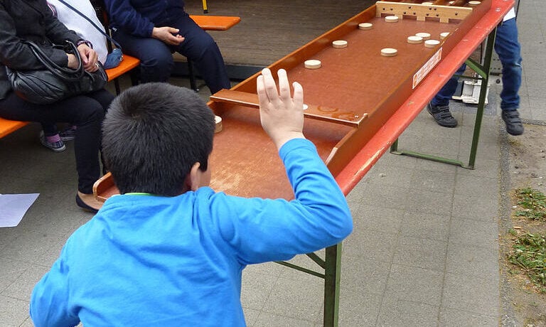 Dutch-children-playing-table-shuffleboard-(sjoelen)-on-king's-day-in-the-netherlands
