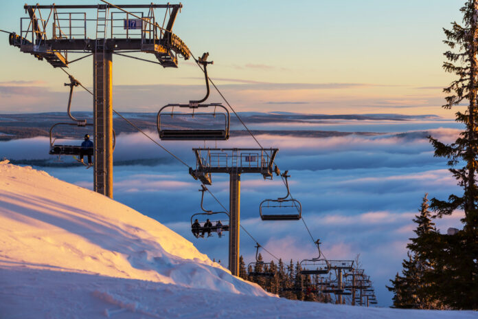 ski-lift-on-snowy-mountain-overlooking-a-clowdy-sky