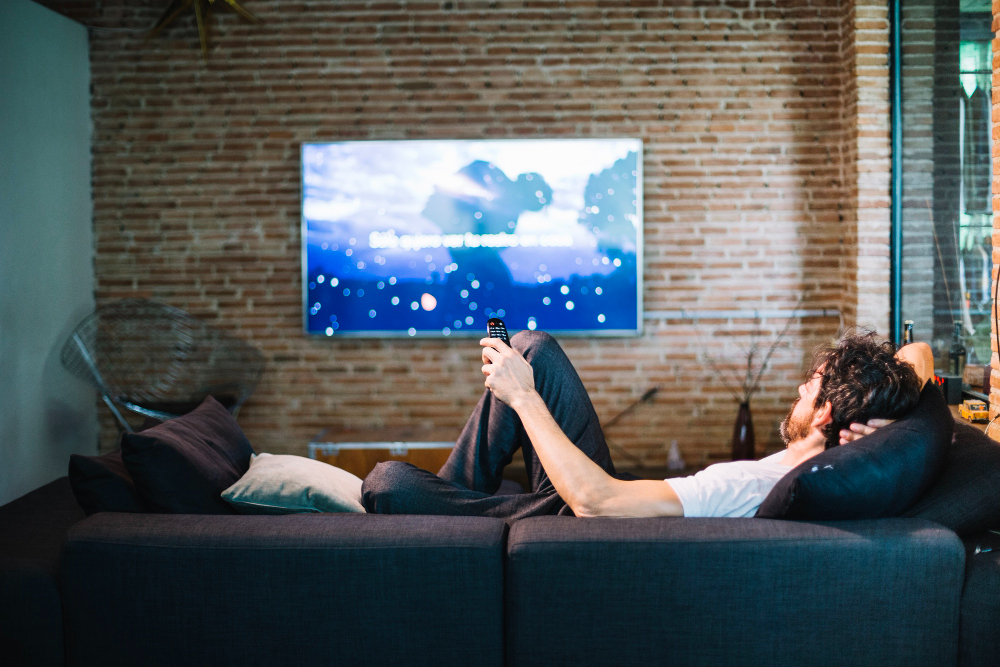photo-of-man-sitting-on-couch-using-streaming-service-in-the-Netherlands