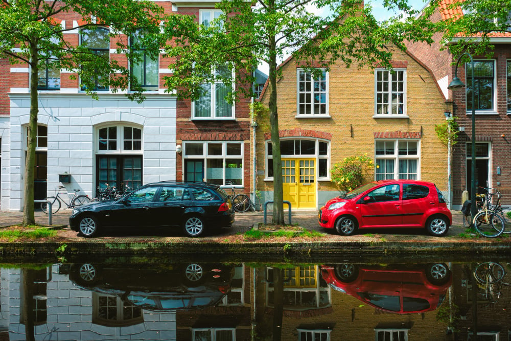 Cars-parked-on-the-street-next-to-a-canal-in-delft