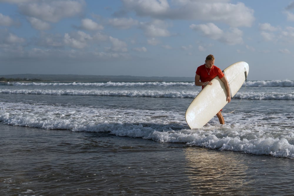 Man-in-a-red-suit-going-surfing-in-texel