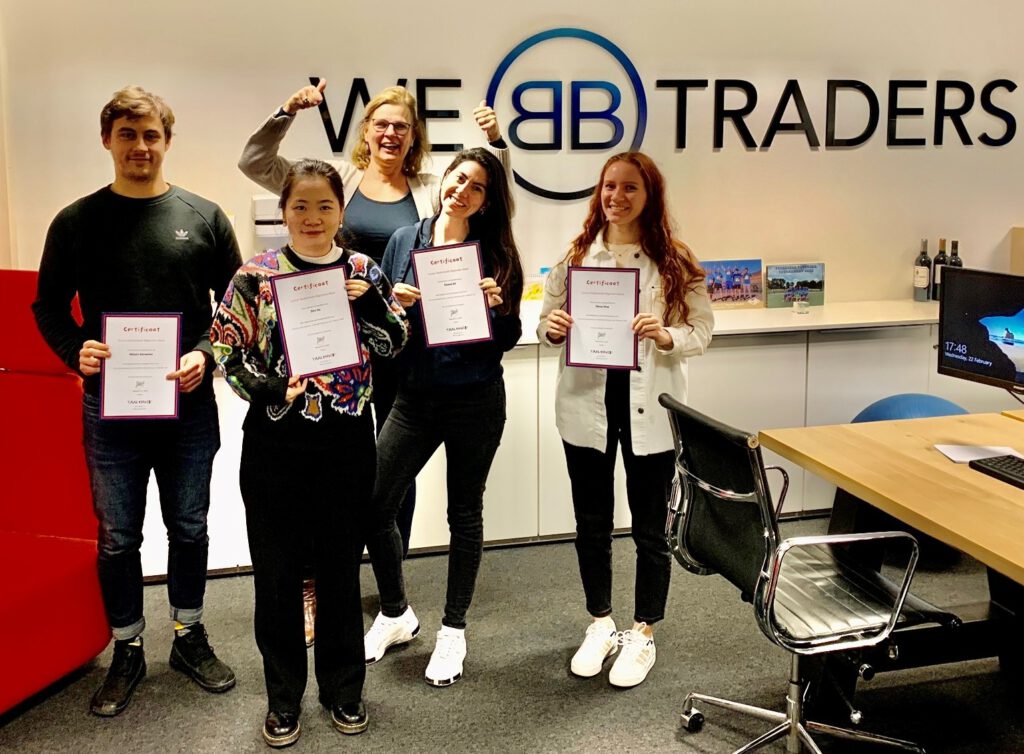 photo-of-four-employees-at-webtraders-and-their-dutch-teacher-holding-certificates-after-completing-taalthuis-in-company-dutch-course