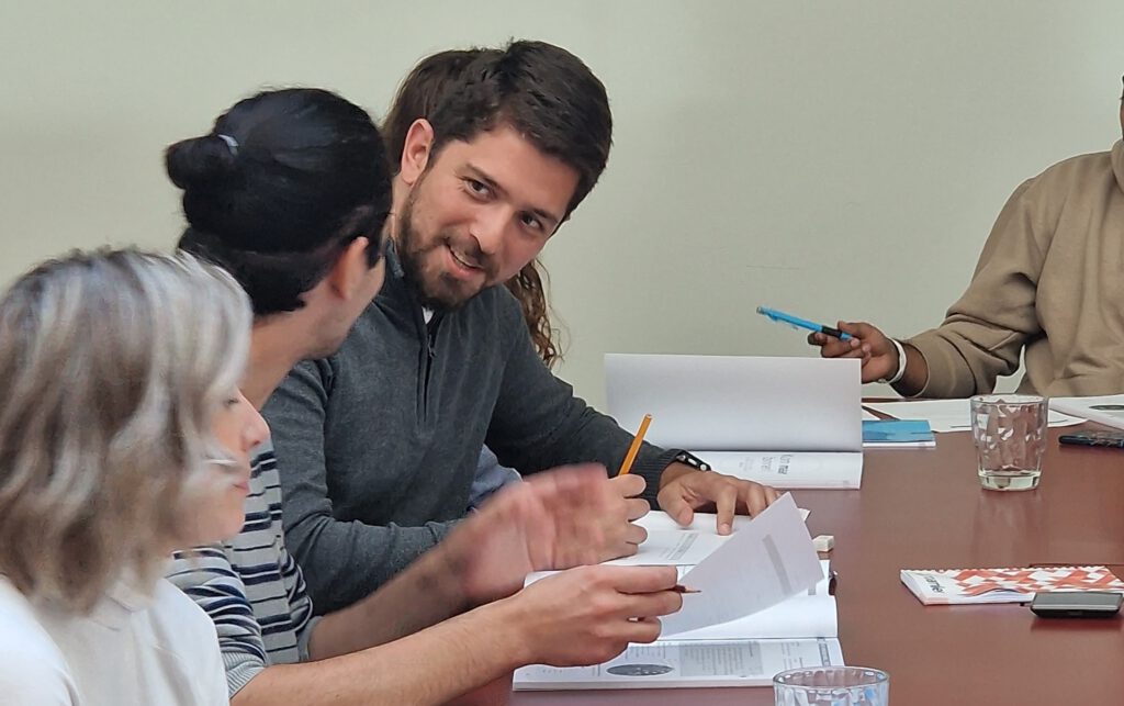 photo-of-two-men-looking-at-each-other-during-in-company-dutch-course-with-one-woman-out-of-focus-in-foreground