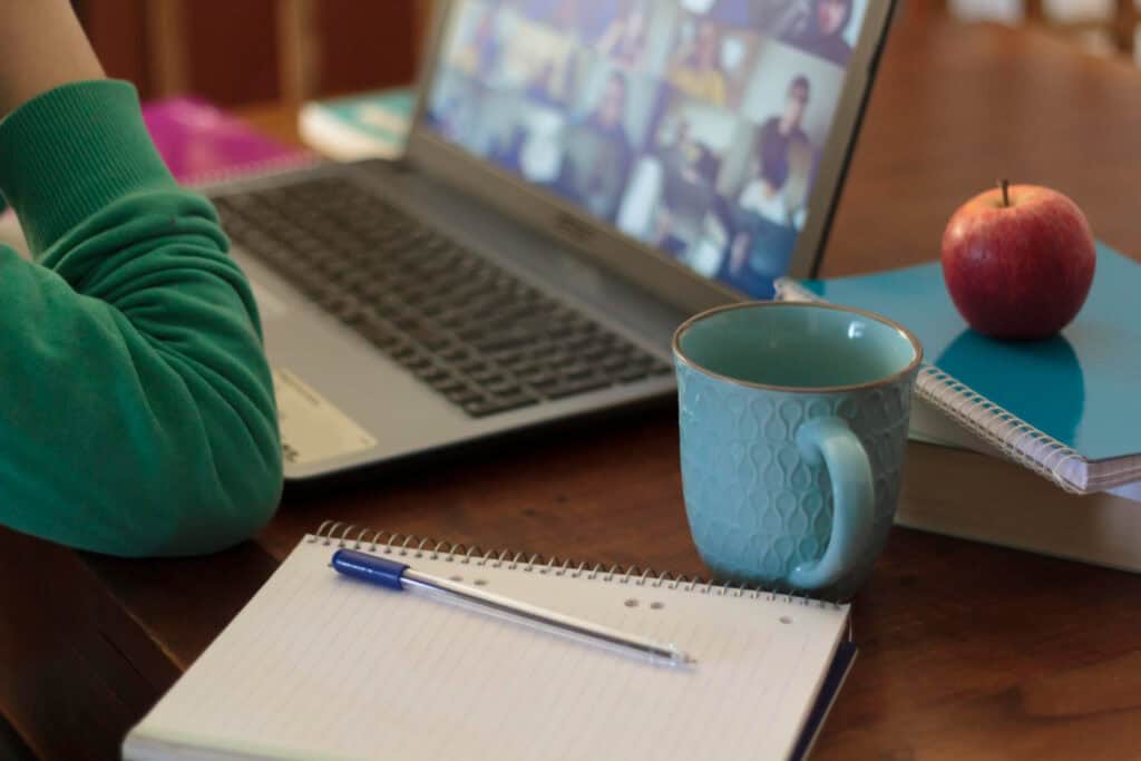 photo-of-cup-notebook-and-pen-next-to-computer-laptop-on-desk-taking-online-Dutch-course