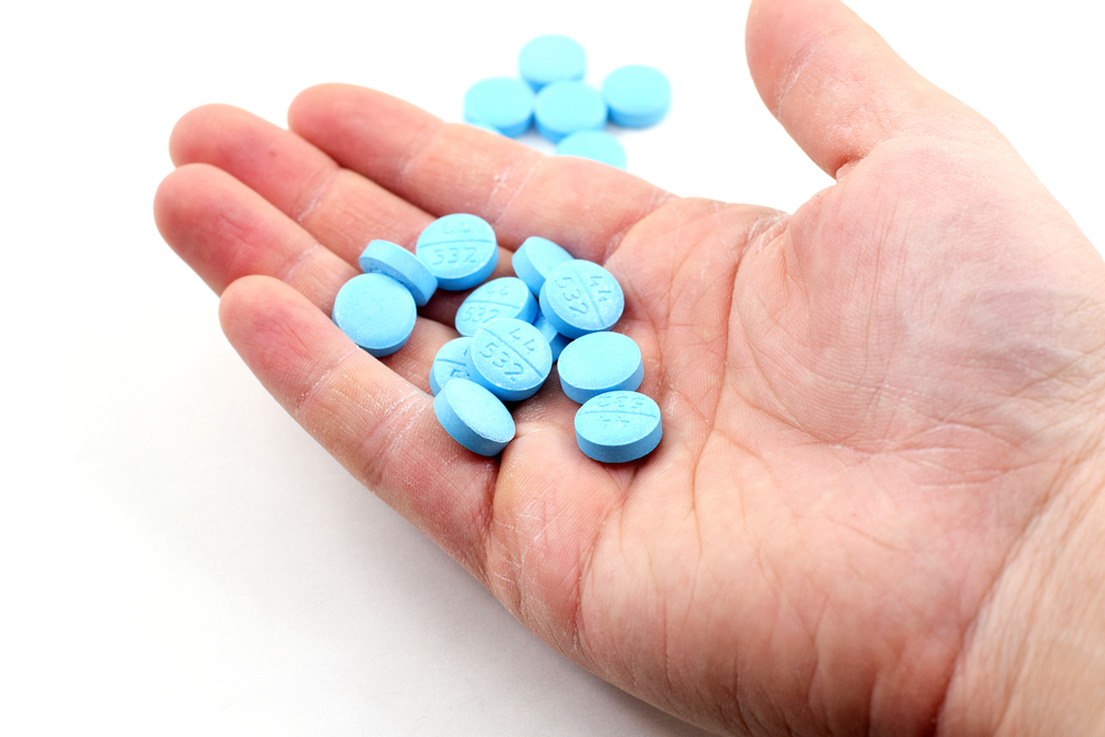 Hand-holding-blue-pills-ecstasy-drug-in-Amsterdam