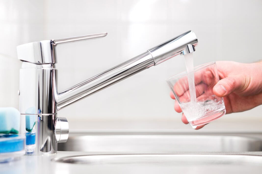 person-filling-cup-from-tap