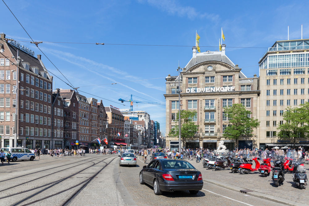 Taxi-cars-people-street-building-in-Amsterdam