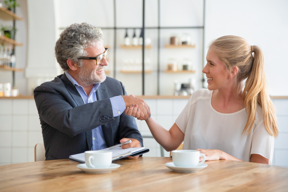 Photo-of-mortgage-expert-shaking-hands-with-woman-talking-about-things-you-dont-know-about-buying-house-in-the-Netherlands