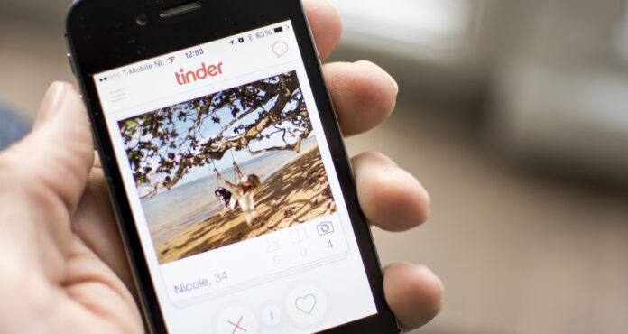 Person-holding-phone-with-the-tinder-app