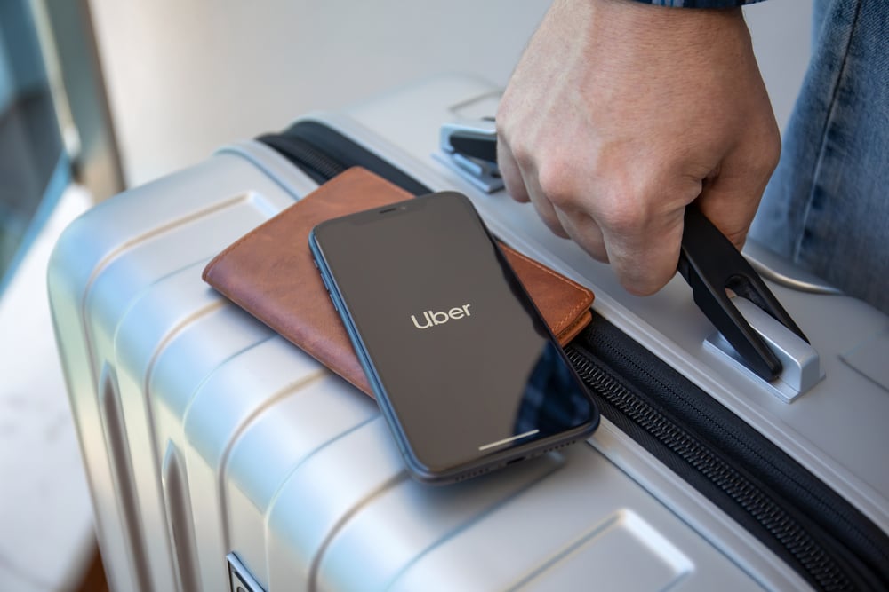 Uber-phone-on-wallet-and-suitcase-to-travel-from-Amsterdam-airport