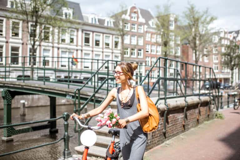 photo-of-woman-with-bike-walking-in-Amsterdam-as-part-of-cycle-tour-Amsterdam