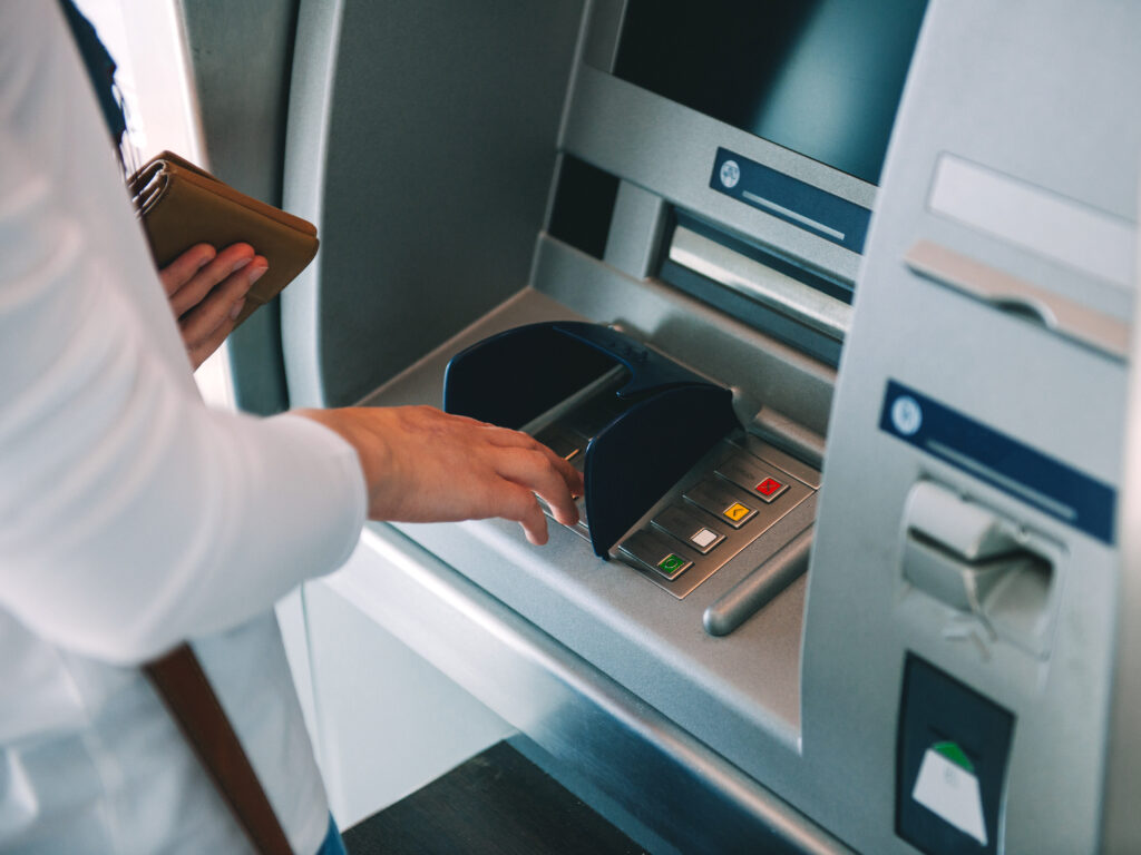 Woman-using-ATM-holding-wallet