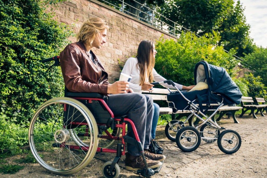 Young-Dutch-couple-in-the-netherlands-with-baby-sitting-down-man-in-wheelchair-accessibility