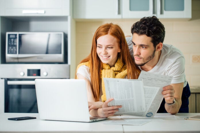 Photo-of-young-couple-looking-at-laptop-calculating-gas-prices