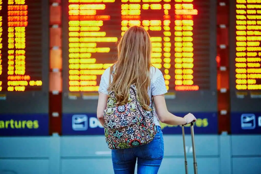 A- picture-of- picture-of-a-woman-waiting-in-front-of-a-departure-board-at-the-airport