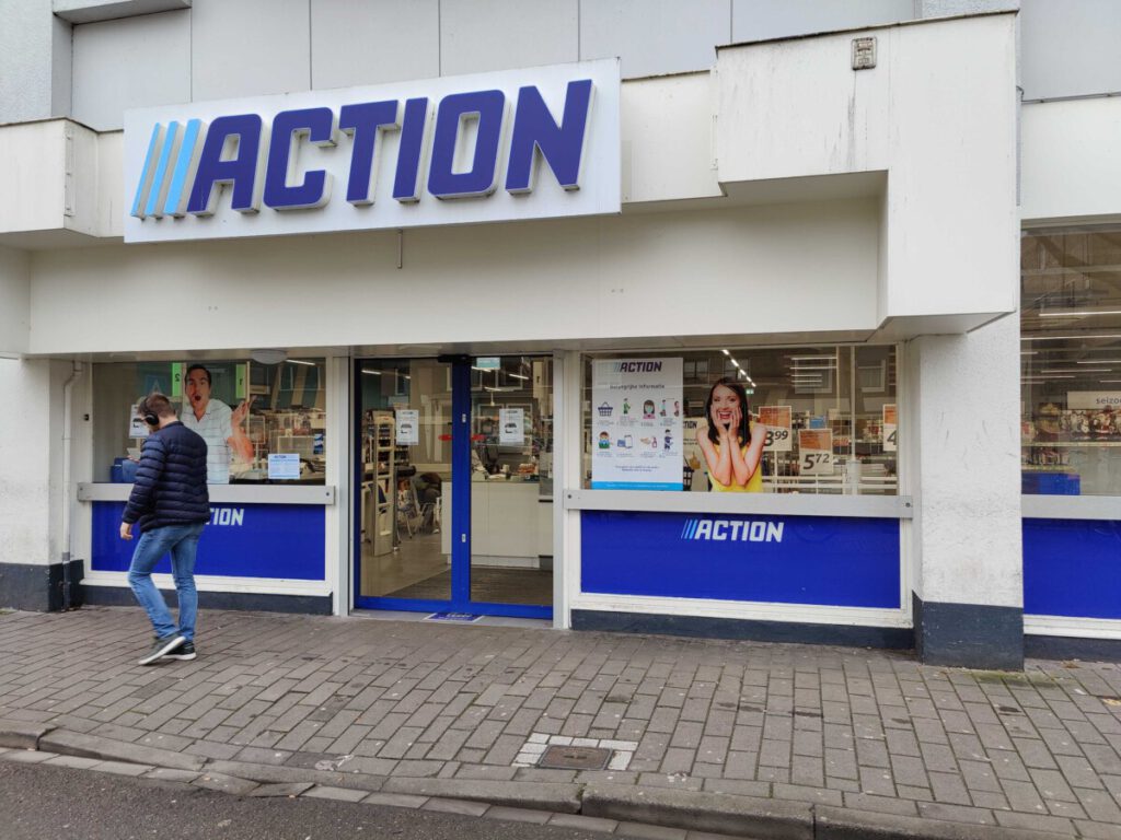 man-walking-in-front-of-action-storefront-a-cheap-shop-in-the-netherlands