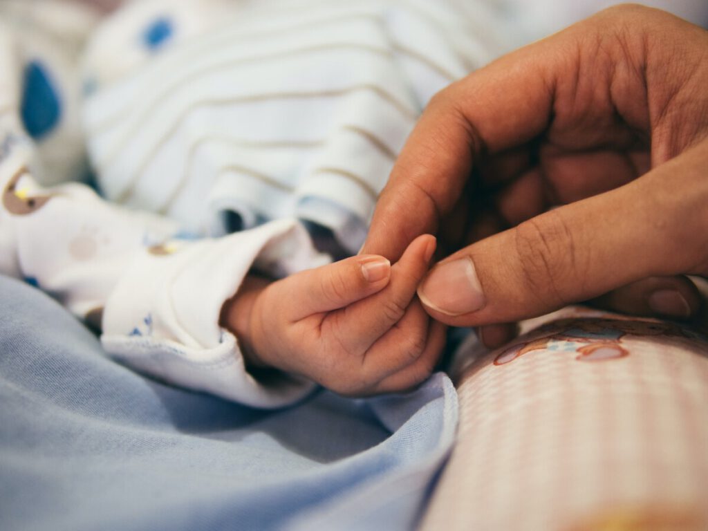 Photo-of-man-holding-baby's-finger-childcare