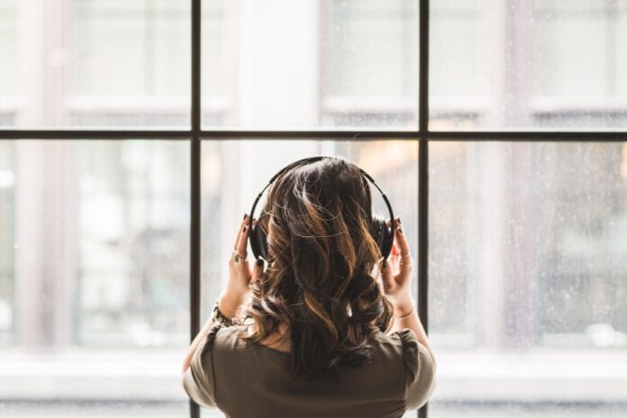 girl-wears-headphones-in-front-of-window