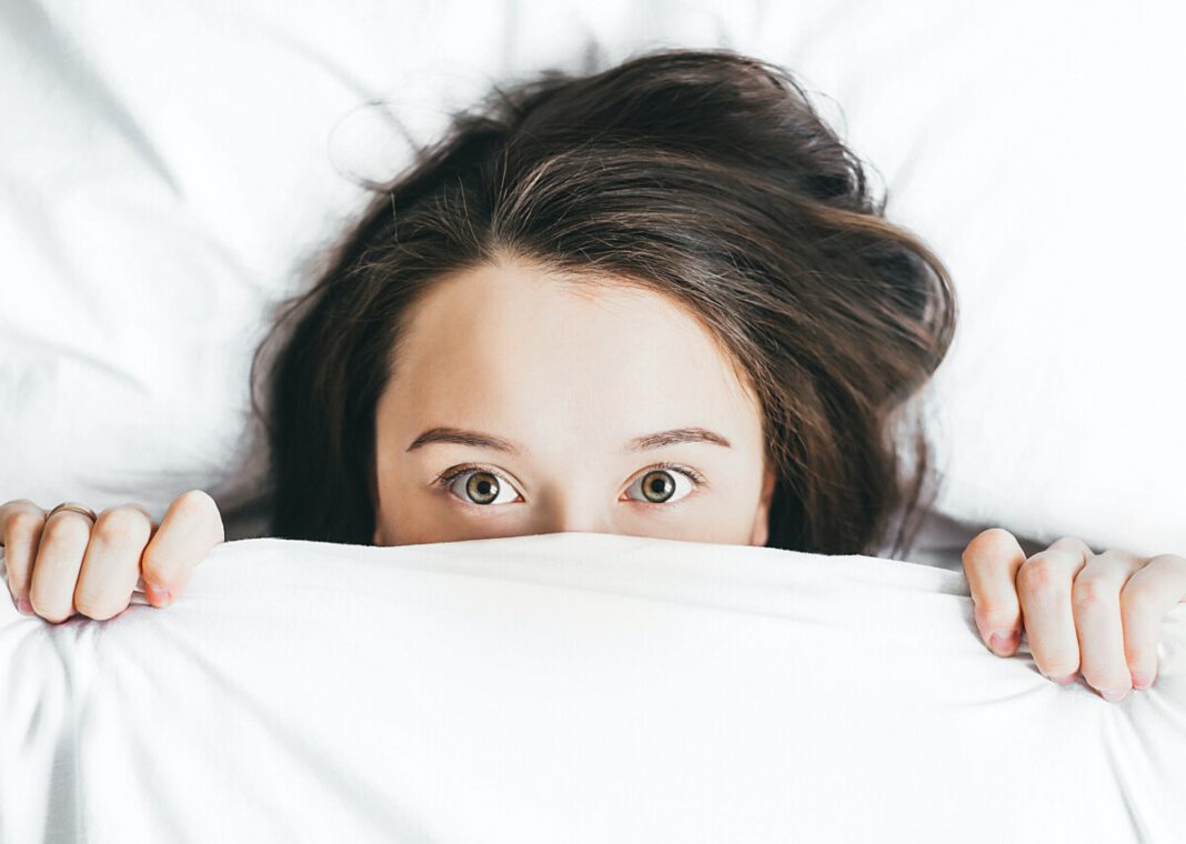 woman-hiding-under-bedcovers