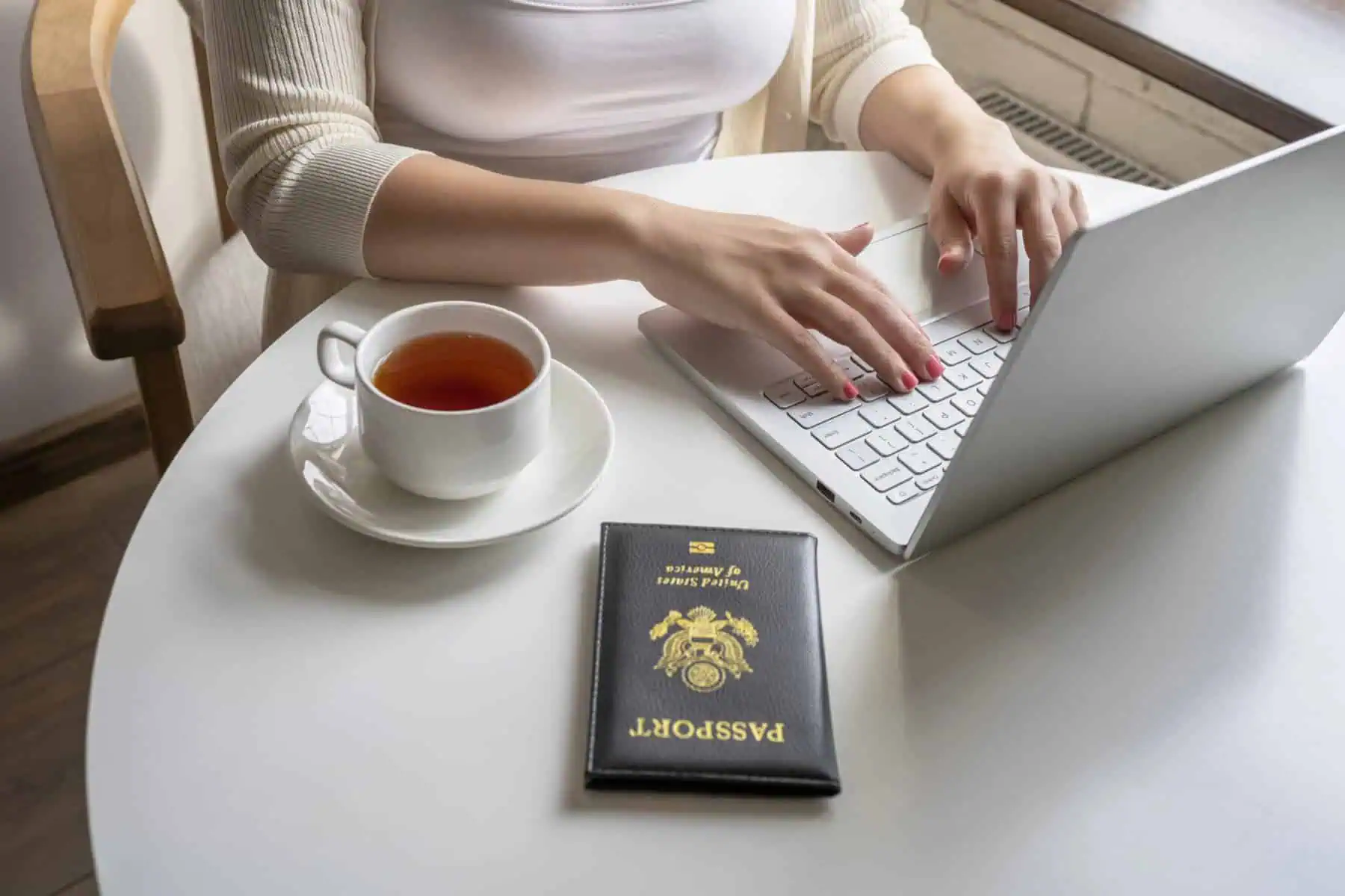 american-woman-applying-for-a-dutch-visa-online-with-her-passport-on-the-table