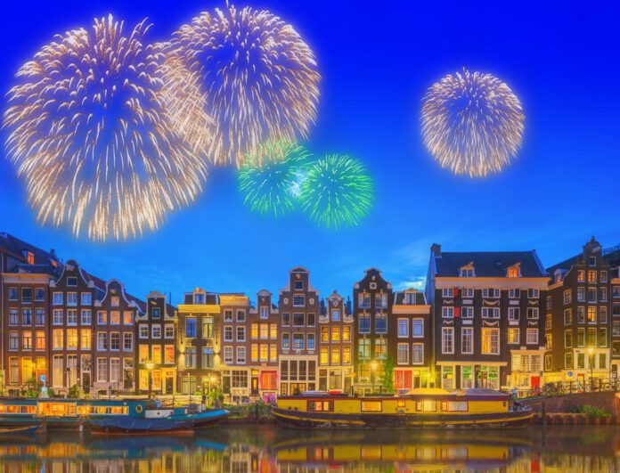 photo-of-amsterdam-canal-houses-with-fireworks-behind-on-a-canal