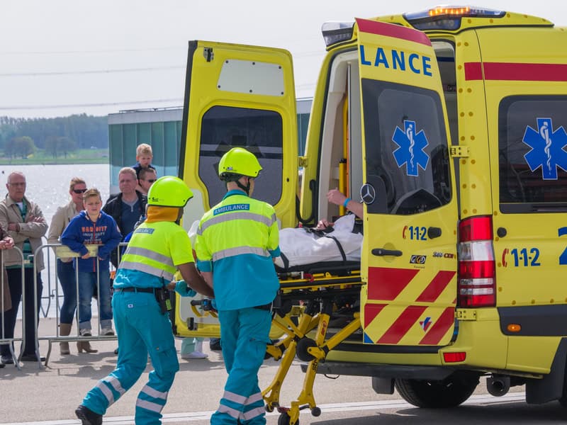 an-injured-person-being-loaded-into-a-dutch-ambulance-while-the-crowd-watches