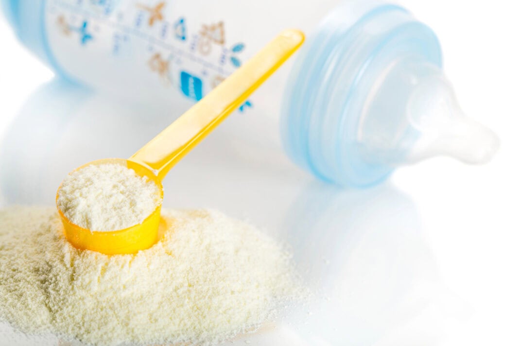 baby-bottle-with-formula-mix-in-measuring-spoon-full-of-formula-in-foreground