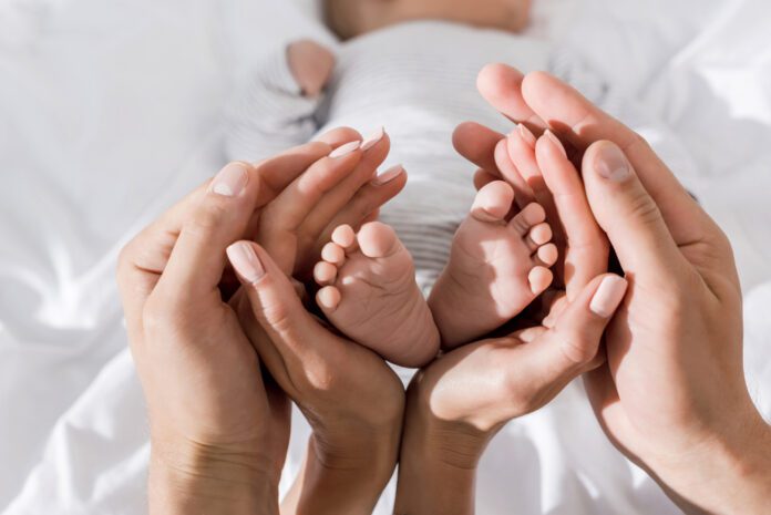 photo-of-parents-hands-with-baby-in-shape-of-heart