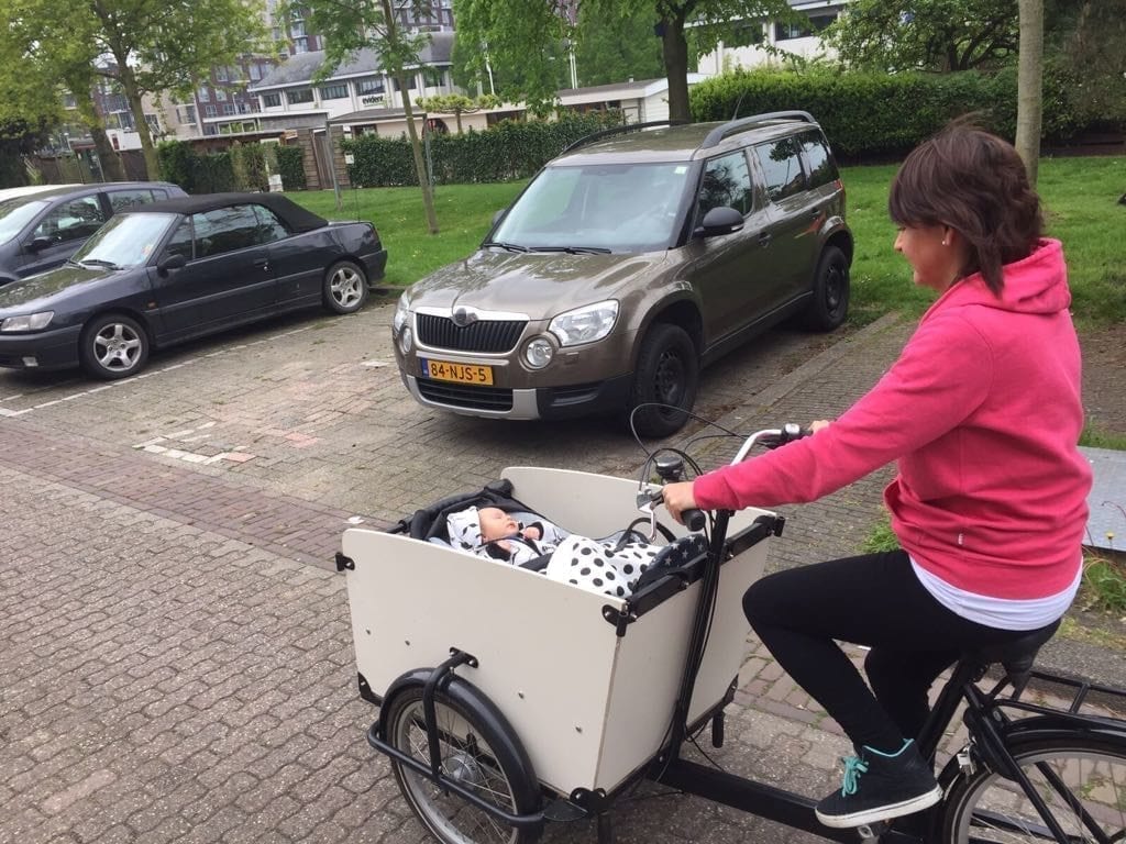 a-mother-riding-a-bike-with-her-baby-in-the-front-in-the-Netherlands