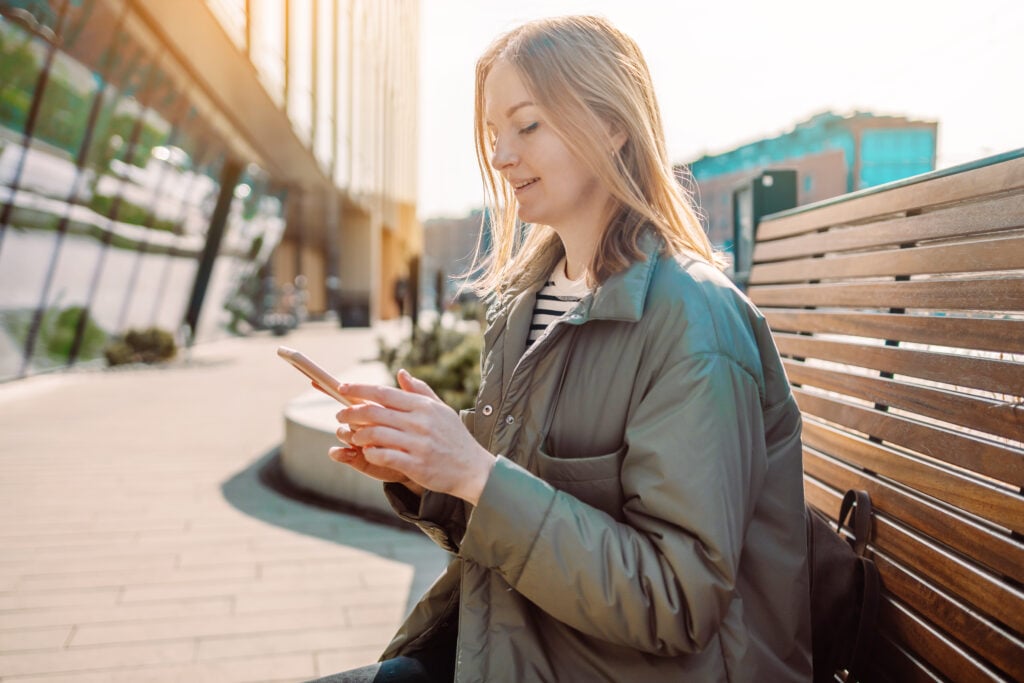 blond-female-tourist-scrolling-on-her-mobile-with-simyo-esim-functionality-in-the-netherlands