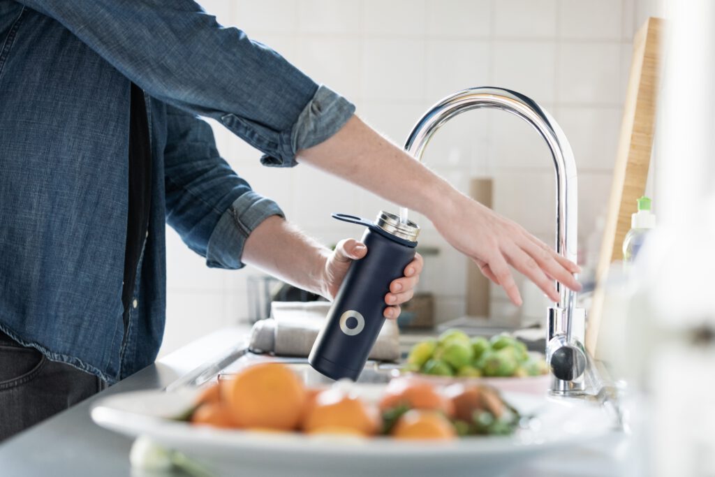 person-filling-water-bottle