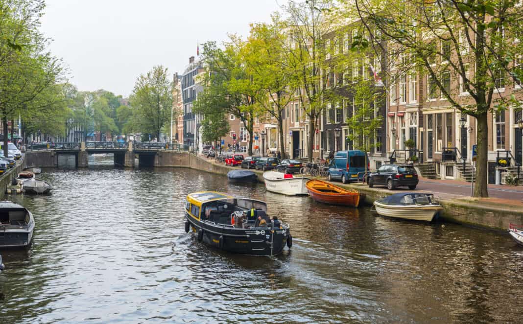 boat-sailing-down-amsterdam-canal-during-canal-cruise