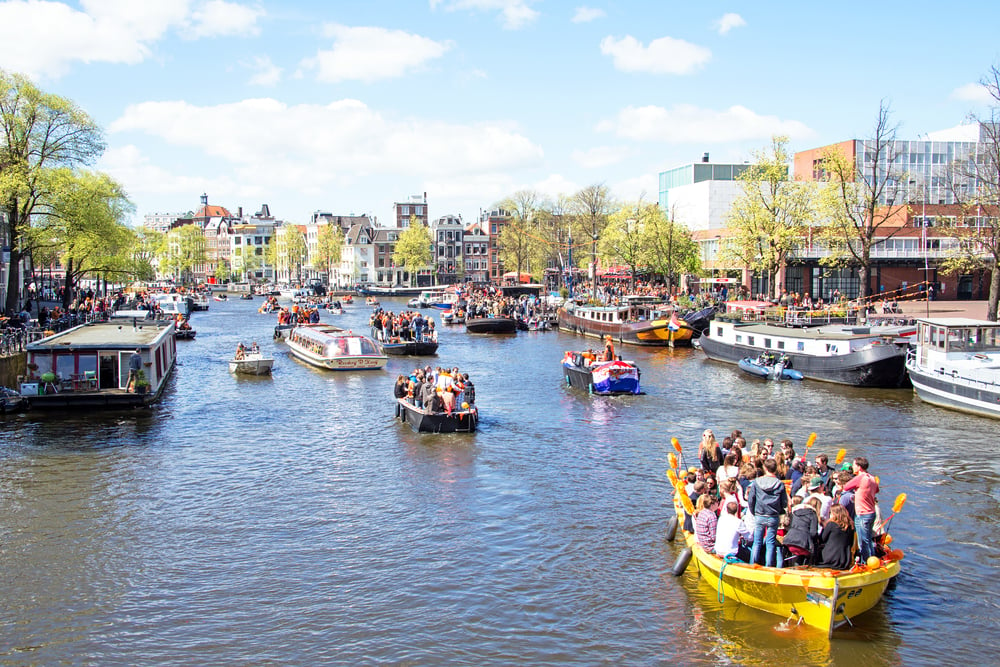 photo-of-boats-along-a-canal-in-amsterdam-on-kings-day