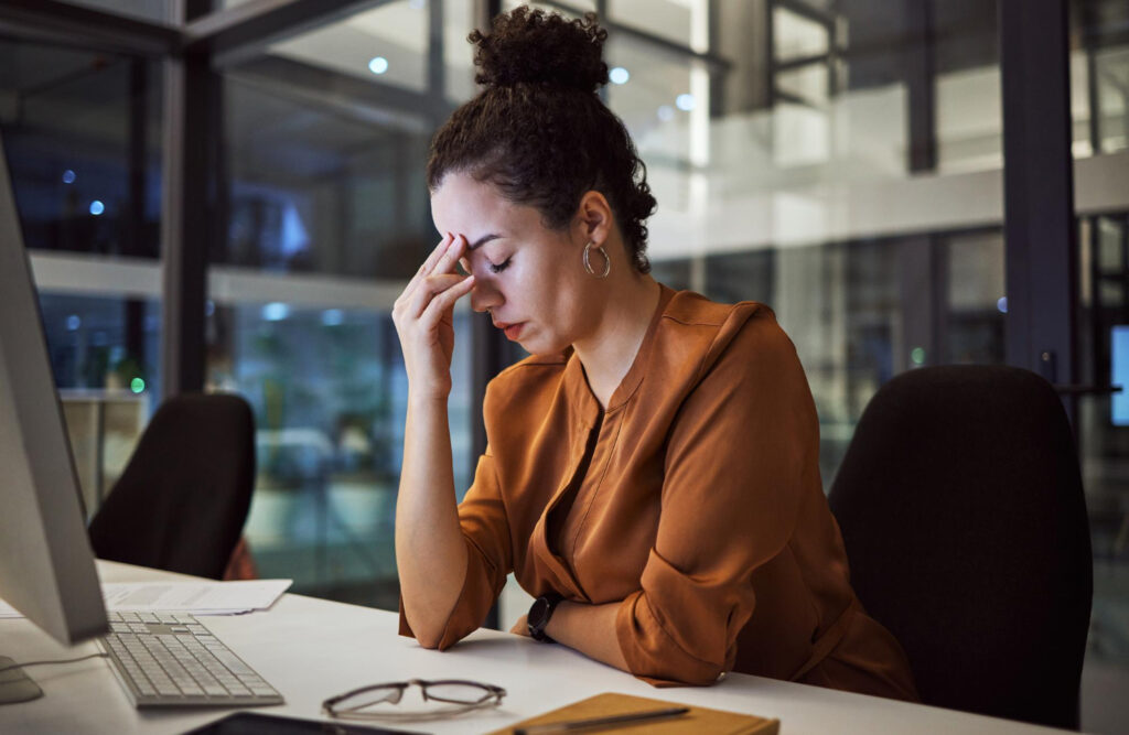 photo-of-international-employee-sitting-at-desk-in-the-Netherlands-looking-stressed-dealing-with-burnout