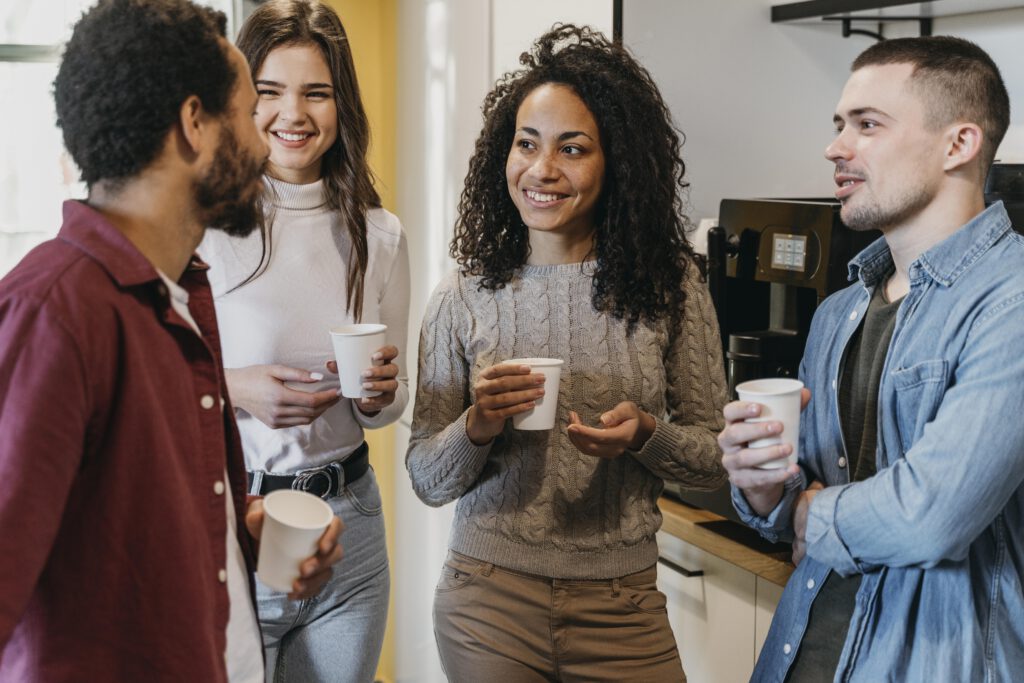 Group-of-young-people-drinking-coffee-in-the-office-next-to-coffee-machine