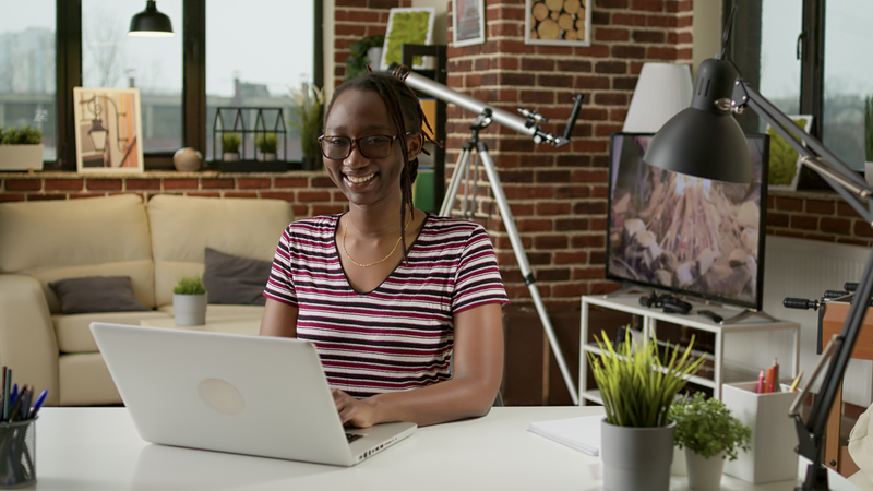 photo-of-woman-sitting-at-desk-with-laptop-attending-hannos-housing-webinar