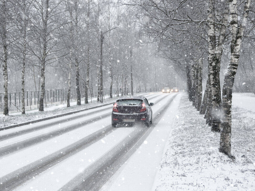 car-driving-down-icy-road-in-the-netherlands-as-snow-falls