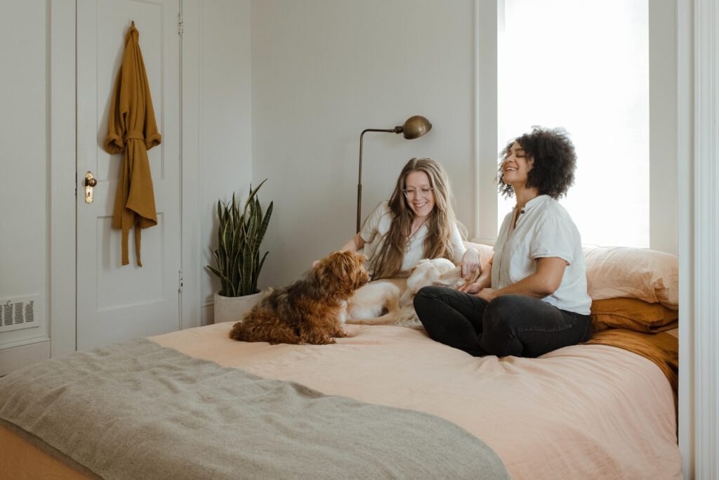 Women-sitting-on-bed-in-furnished-apartment-with-dog