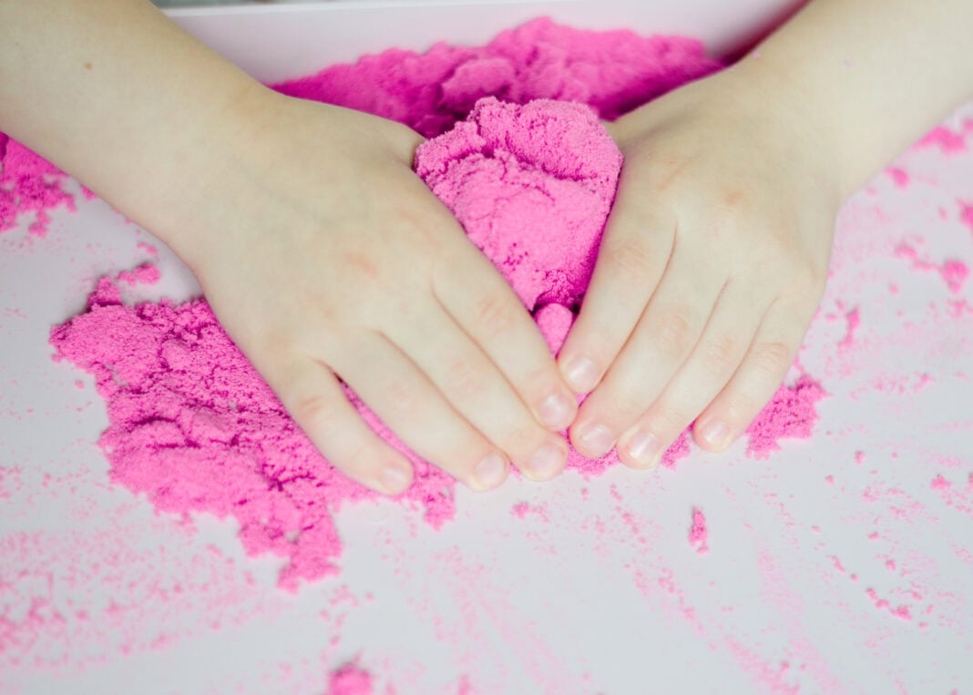 photo-of-childs-hands-playing-with-pink-childrens-play-sand