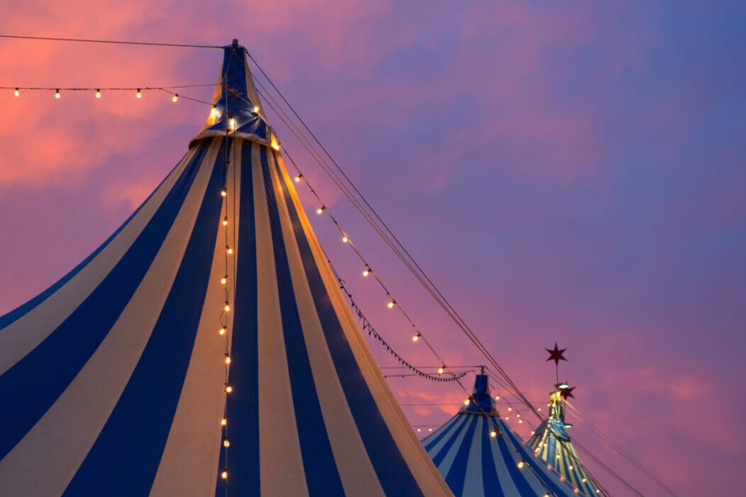 Circus tent in a dramatic sunset sky colorful orange blue with lights