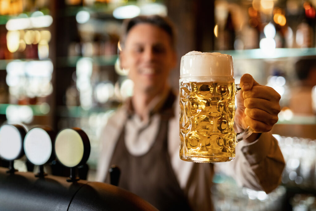 closeup-photo-of-barista-holding-glass-heineken-beer-at-bar