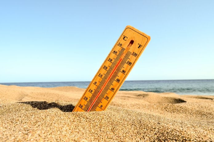 closeup-shot-thermometer-half-submerged-in-beach-sand-scaled