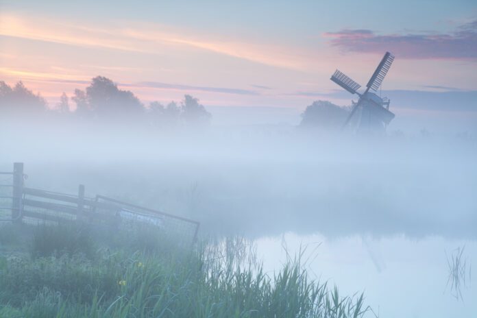 misty-sunrise-over-Dutch-windmill-on-farmland-Netherlands