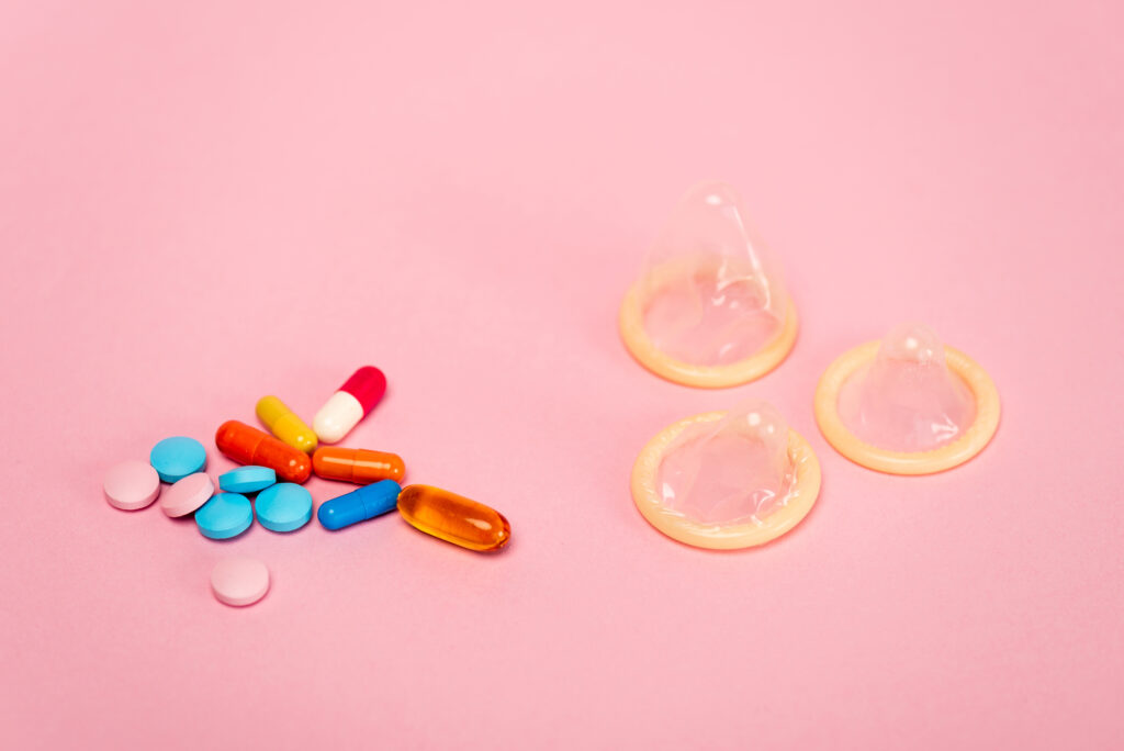 birth-control-pills-and-condoms-with-pink-background