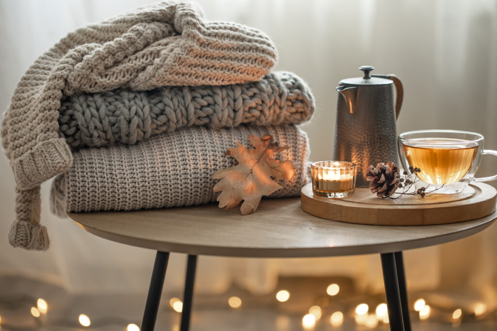 cosy-knitted-sweaters-sitting-next-to-a-cup-of-tea-on-a-table