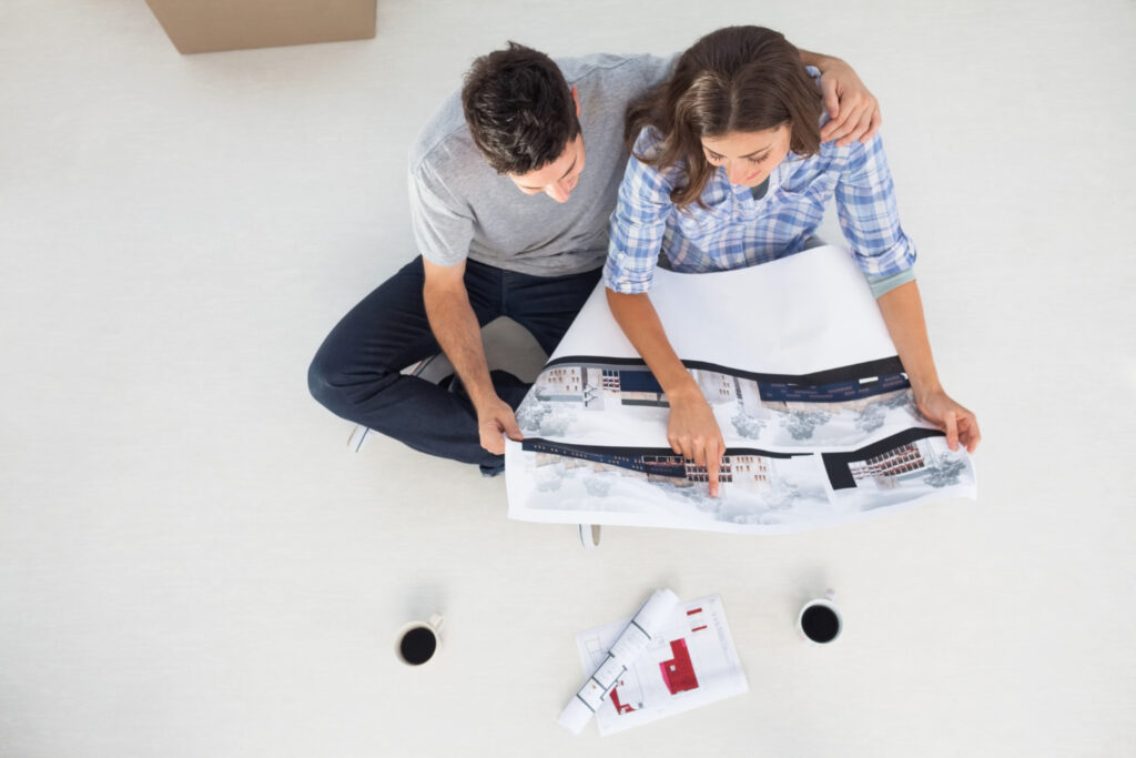 photo-of-couple-sitting-on-floor-inspecting-printout-of-new-build-in-amsterdam