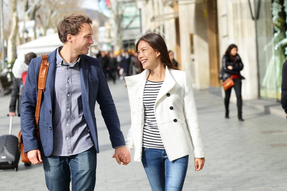 couple-walking-holding-hands-on-sidewalk