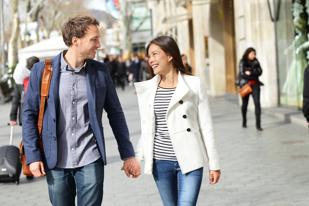 couple-walking-holding-hands-on-sidewalk